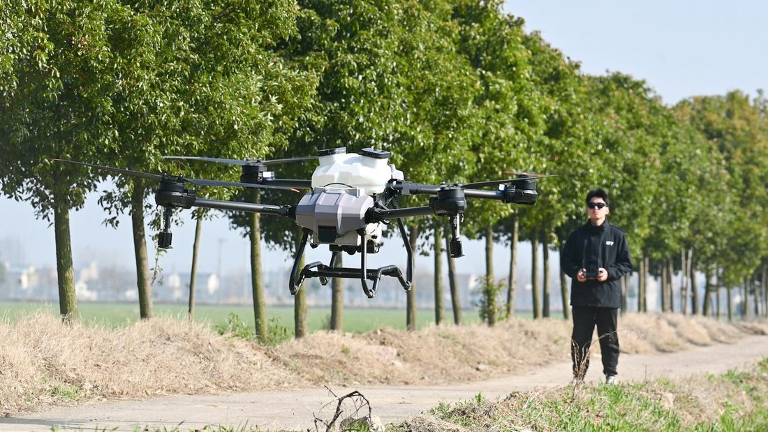 Piloto operando un dron agrícola con control remoto